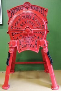 Philip Pierce & Co. turnip cutter fully restored and painted red on display at Sligo Folk Park