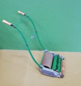Vintage push lawn mower restored and painted green, part of the heritage collection at Sligo Folk Park
